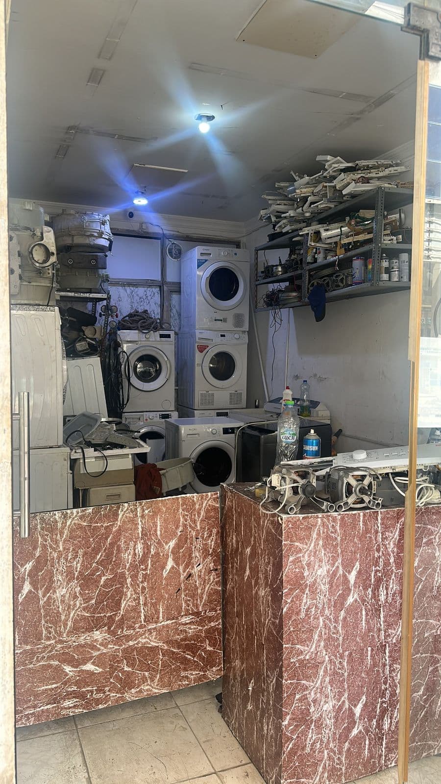 Repair workshop with washing machines, dryers and spare parts