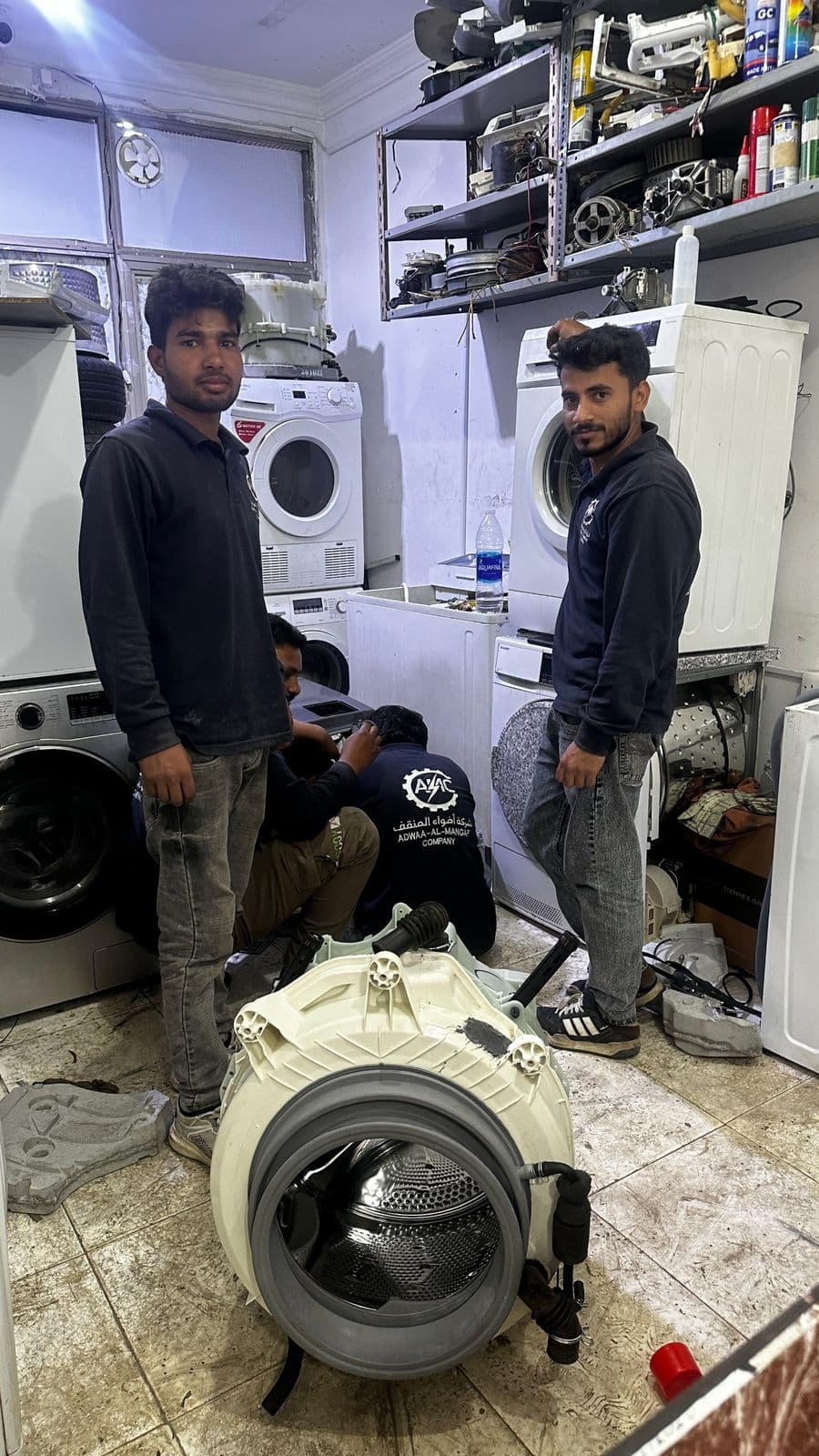 Technicians repairing a washing machine in the workshop