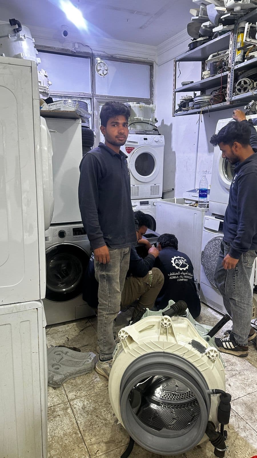 Team members at work on a washing machine in the workshop